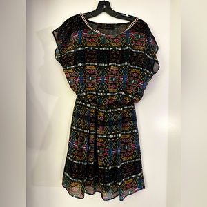 Flowy mini dress, black with vibrant geometric pattern, ribbon trim